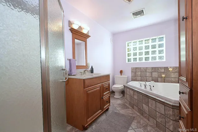 a bathroom with a tub sink and mirror