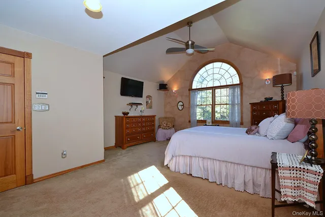 a bedroom with a bed and a large window