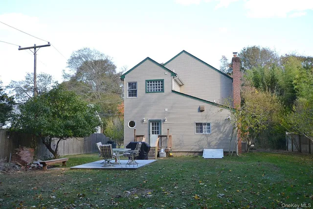 a view of a chair and table in backyard of the house