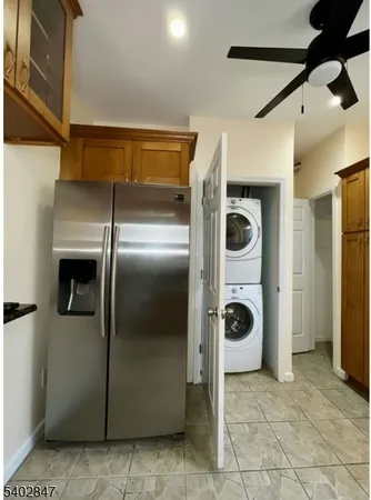 a view of a refrigerator in kitchen and utility room with wooden floor