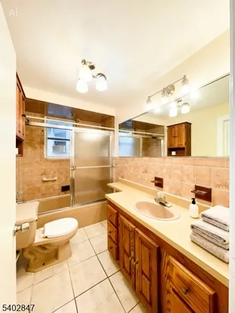 a bathroom with a double vanity sink mirror and toilet