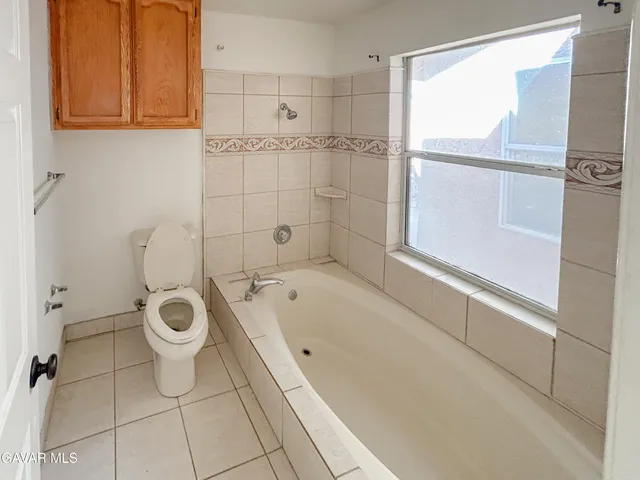 a bathroom with a granite countertop sink a toilet and bathtub