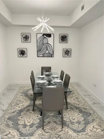 a living room with couch a large window and a chandelier