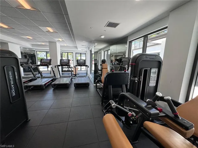 a view of a patio with wooden chairs and a potted plant