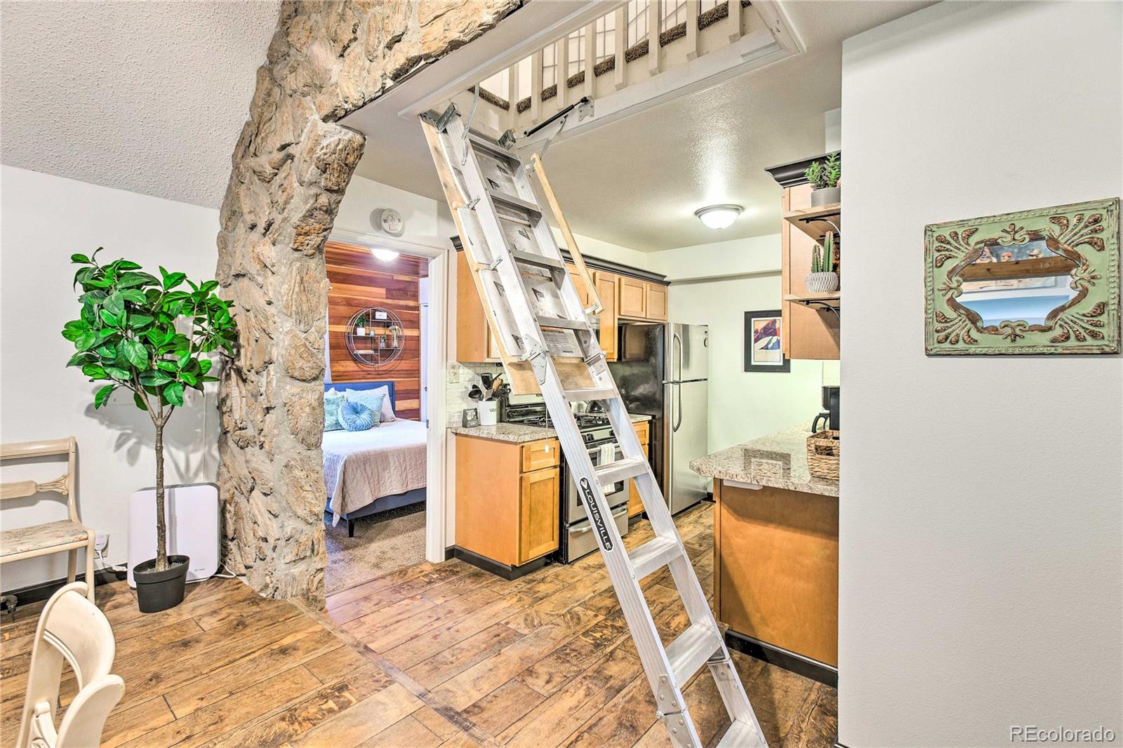 7559 South Turkey Creek Road Morrison, CO 80465 - Photo 14 of 40 a view of a bedroom with a bed and a potted plant