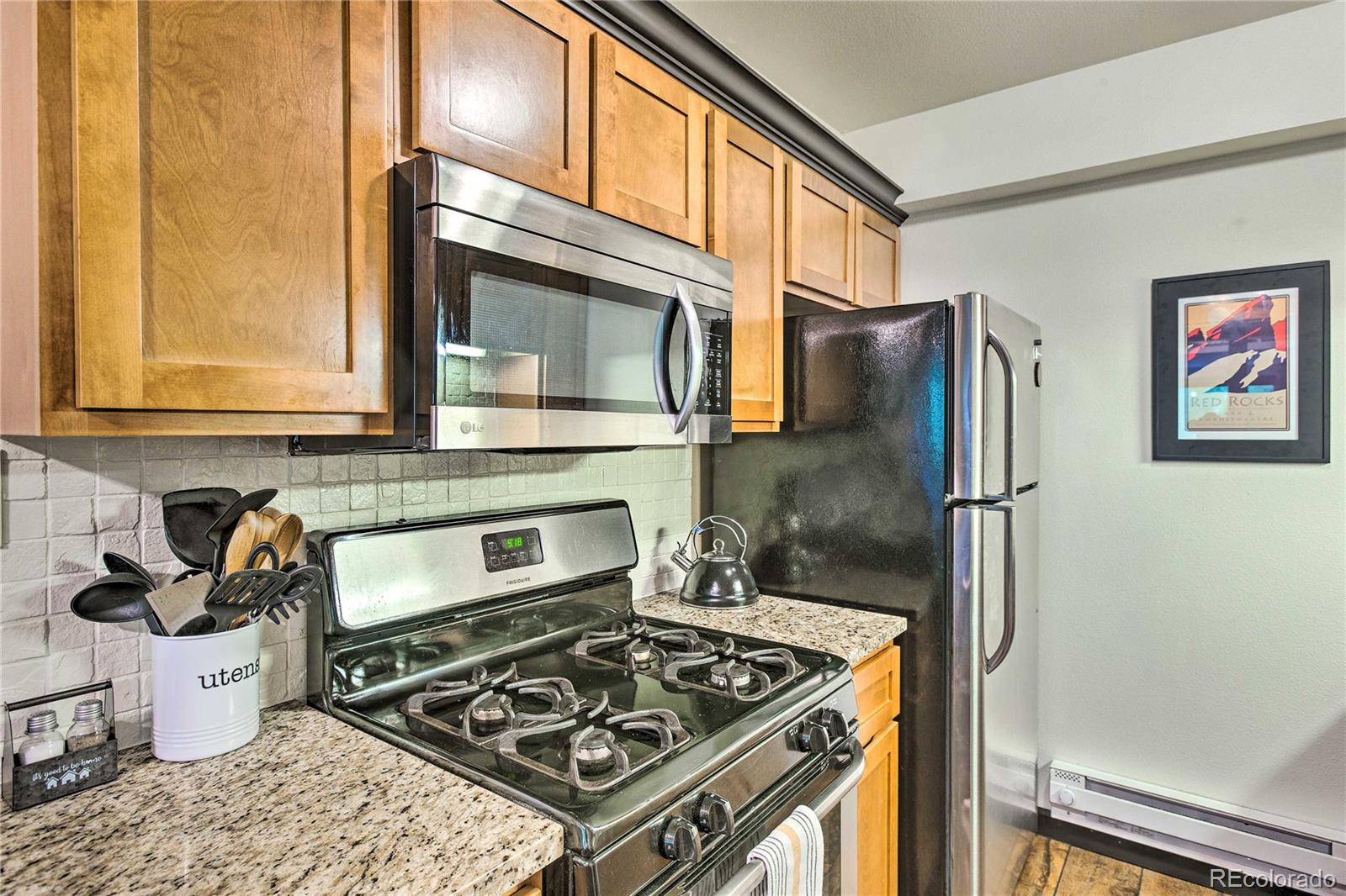 7559 South Turkey Creek Road Morrison, CO 80465 - Photo 17 of 40 a kitchen with stainless steel appliances granite countertop a stove a refrigerator and a microwave