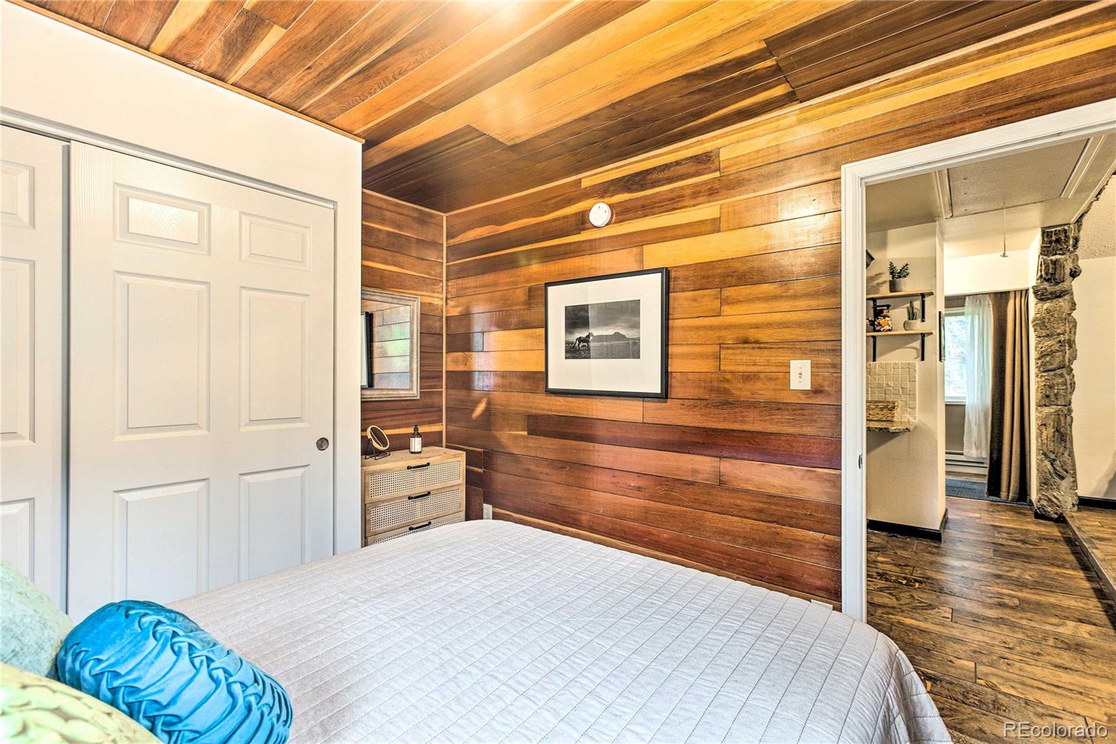 7559 South Turkey Creek Road Morrison, CO 80465 - Photo 18 of 40 a bedroom with a bed and wooden floor