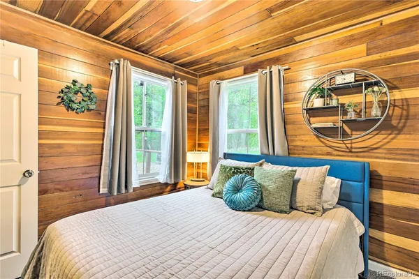 a bedroom with a bed a mirror and a window