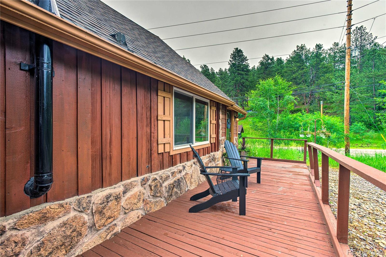 7559 South Turkey Creek Road Morrison, CO 80465 - Photo 31 of 40 a balcony with wooden floor and outdoor seating