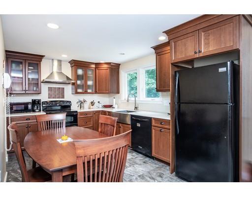 40 Woodruff Road Walpole, MA 02081 - Photo 13 of 31 a kitchen with stainless steel appliances granite countertop a refrigerator a sink a stove a dining table and chairs