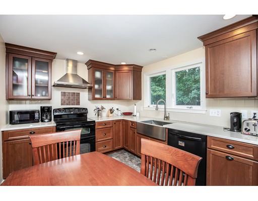 40 Woodruff Road Walpole, MA 02081 - Photo 9 of 31 a kitchen with stainless steel appliances granite countertop a stove top oven a sink dishwasher a dining table and chairs with wooden floor