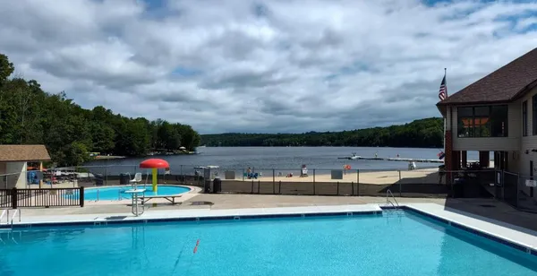 a view of swimming pool with seating area and barbeque oven in the back