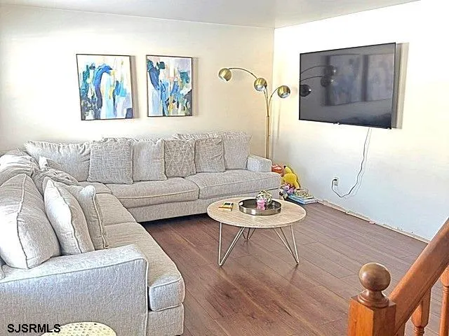 a living room with furniture and a wooden floor