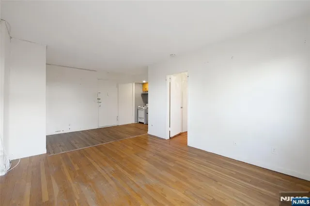 a view of an empty room with wooden floor