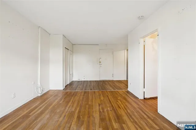 a view of a room with wooden floor and white walls