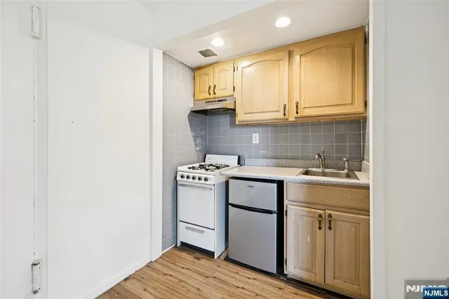 a kitchen with a sink cabinets and wooden floor