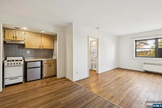 a kitchen with granite countertop a stove a sink and a refrigerator