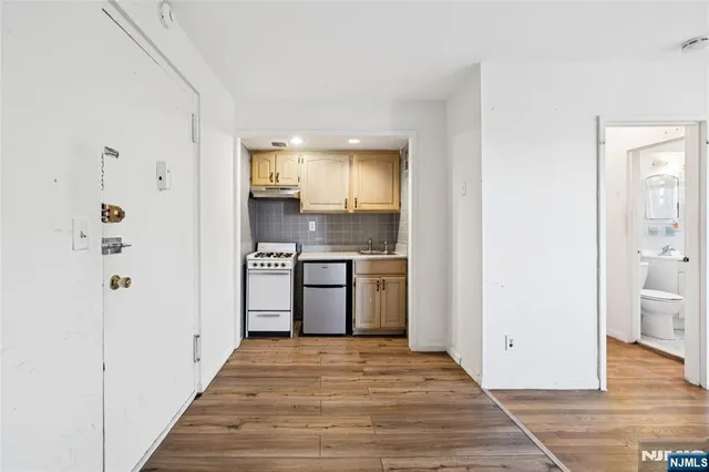 a view of a kitchen with a sink and dishwasher with wooden floor