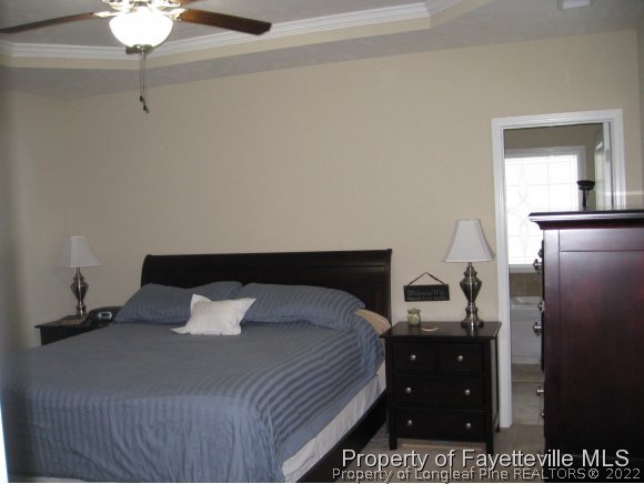 49 Germantown Road Cameron, NC 28326 - Photo 16 of 25 a bedroom with a bed and a chandelier