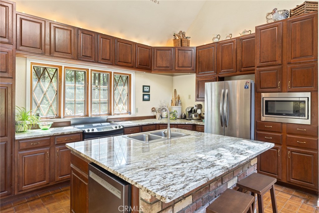 5555 Platt Mountain Road Forest Ranch, CA 95942 - Photo 13 of 55 a kitchen with kitchen island granite countertop wooden cabinets a refrigerator and a sink
