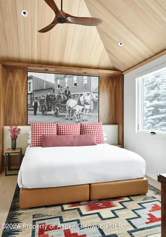 a bedroom with a bed a dresser and next to a window