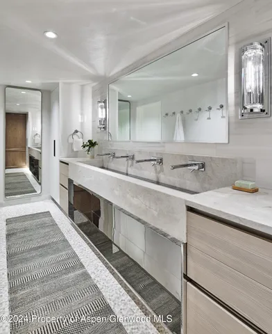 a spacious bathroom with double sink and a mirror