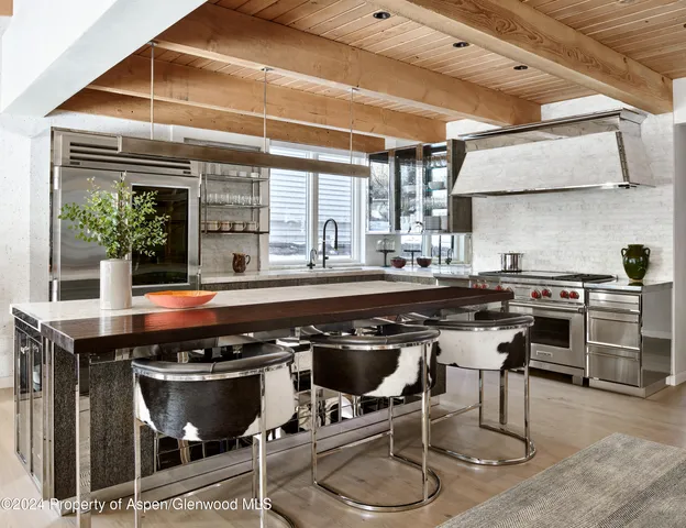 a kitchen with a stove a table and chairs in it