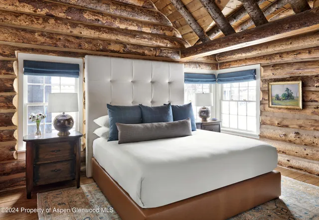 a large bedroom with a bed and wooden floor
