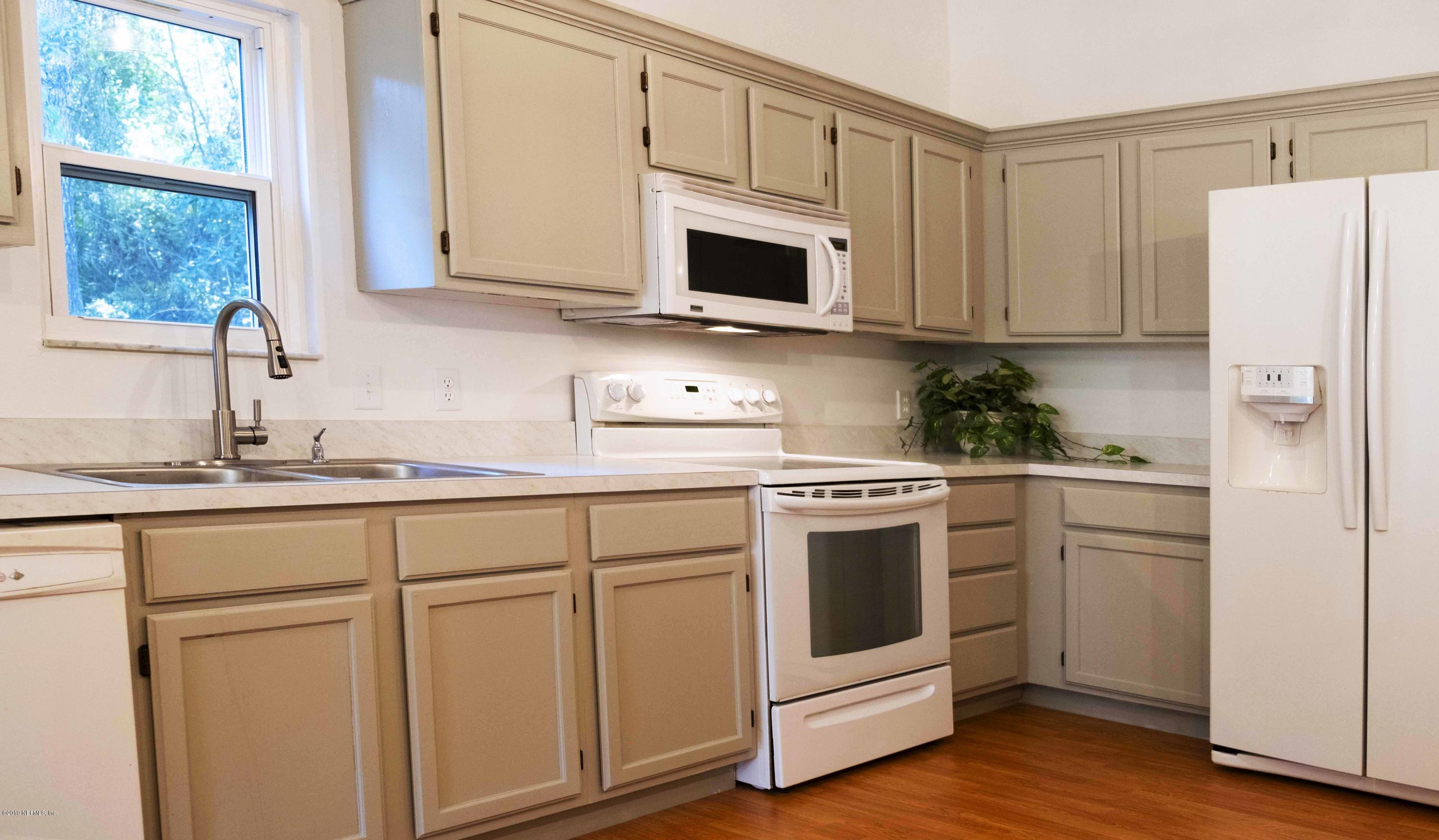133 Shamrock Road St. Augustine, FL 32086 - Photo 12 of 31 a kitchen with white cabinets and white appliances