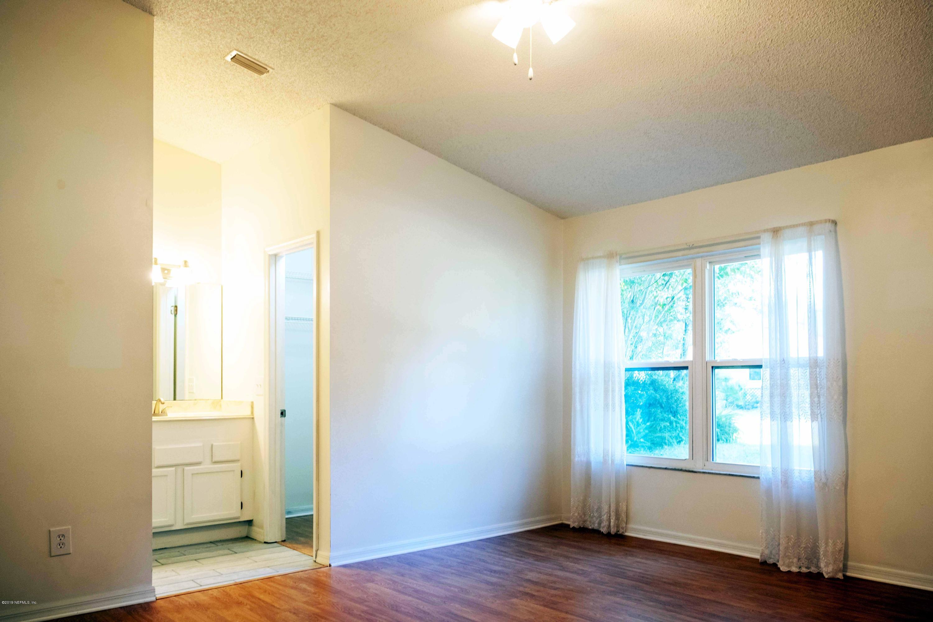 133 Shamrock Road St. Augustine, FL 32086 - Photo 13 of 31 a view of an empty room with wooden floor and a window