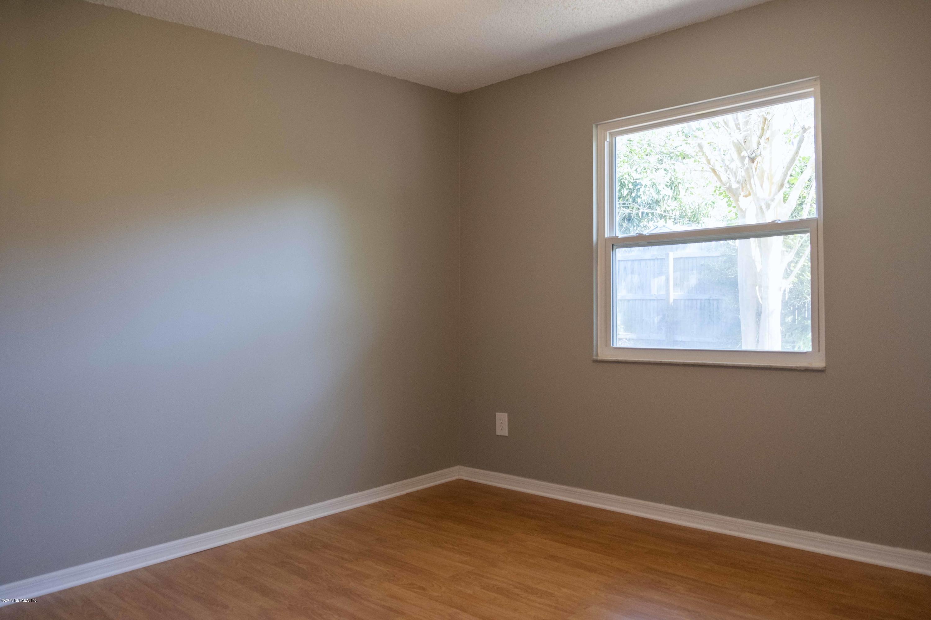 133 Shamrock Road St. Augustine, FL 32086 - Photo 20 of 31 an empty room with wooden floor and windows