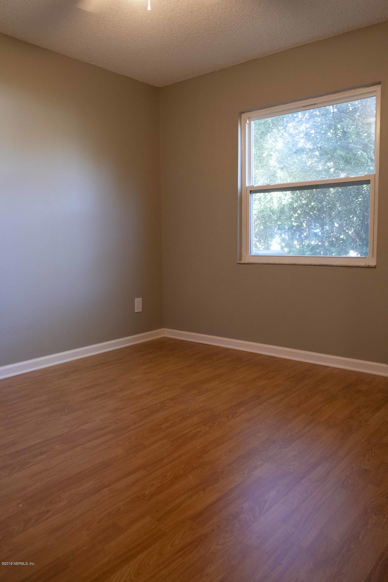 133 Shamrock Road St. Augustine, FL 32086 - Photo 26 of 31 a view of an empty room with wooden floor and a window