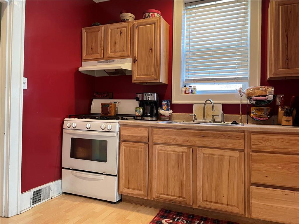 321 Elm Road Ambridge, PA 15003 - Photo 10 of 25 a kitchen with granite countertop a sink a stove and cabinets