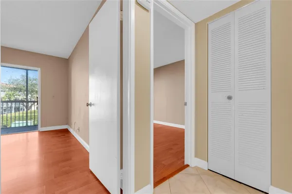 a view of an empty room with closet and a window