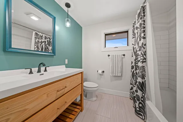 a bathroom with a sink a toilet and a mirror