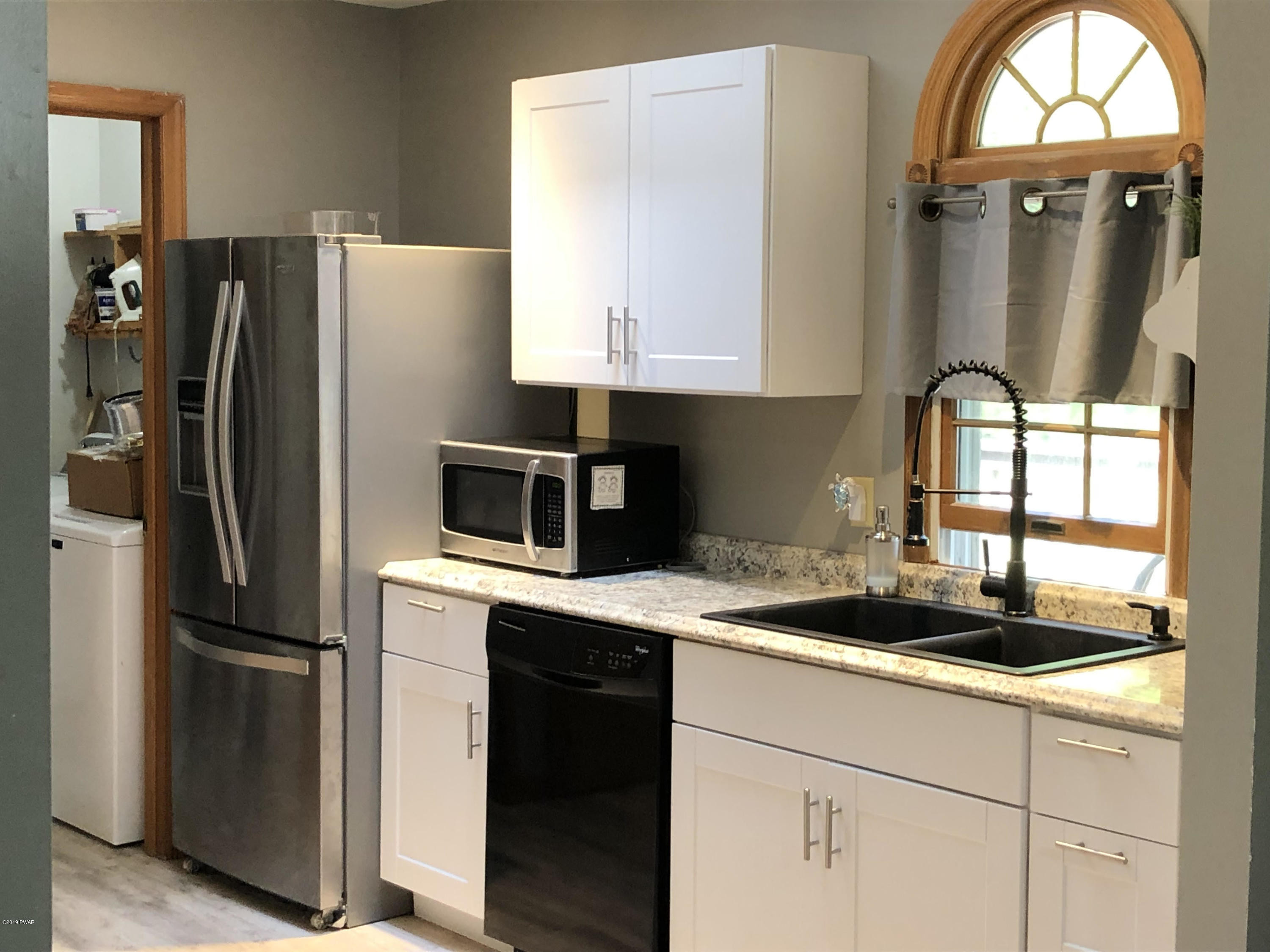 110 Weasel Road Dingmans Ferry, PA 18328 - Photo 13 of 39 a kitchen with a refrigerator a sink and cabinets