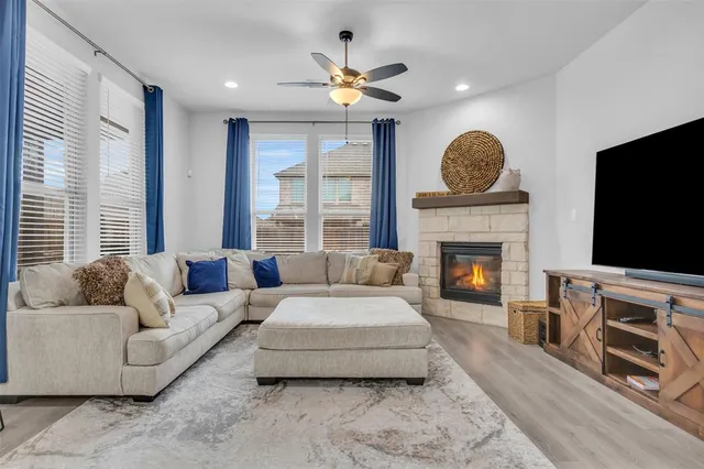 a living room with furniture a large window and a fireplace