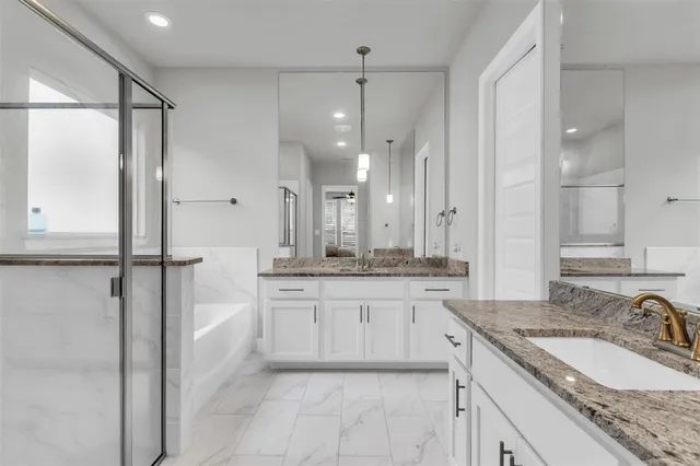 a bathroom with a granite countertop bathtub shower sink and mirror