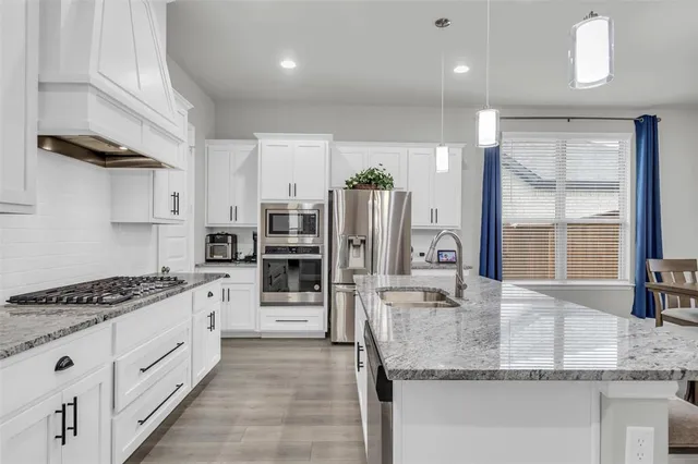 a kitchen with a table chairs refrigerator and cabinets