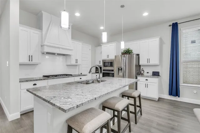 a kitchen with stainless steel appliances granite countertop a sink stove and refrigerator