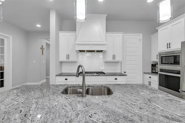 a kitchen with stainless steel appliances granite countertop a kitchen island hardwood floor sink and stove