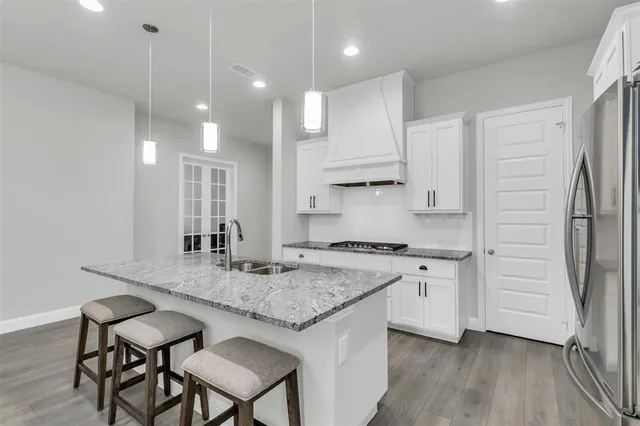 a kitchen with stainless steel appliances granite countertop a sink stove and cabinets