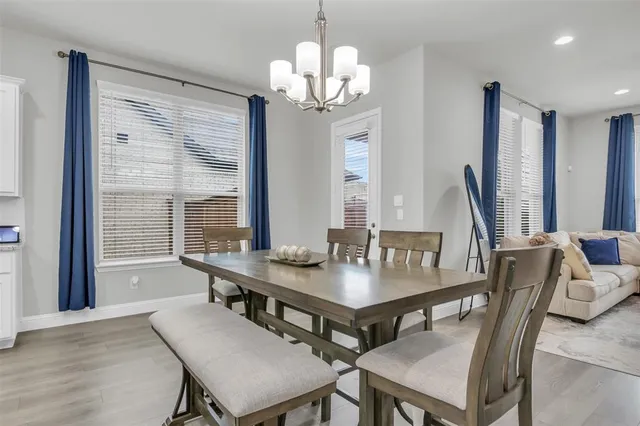 a view of a dining room with furniture a chandelier and wooden floor