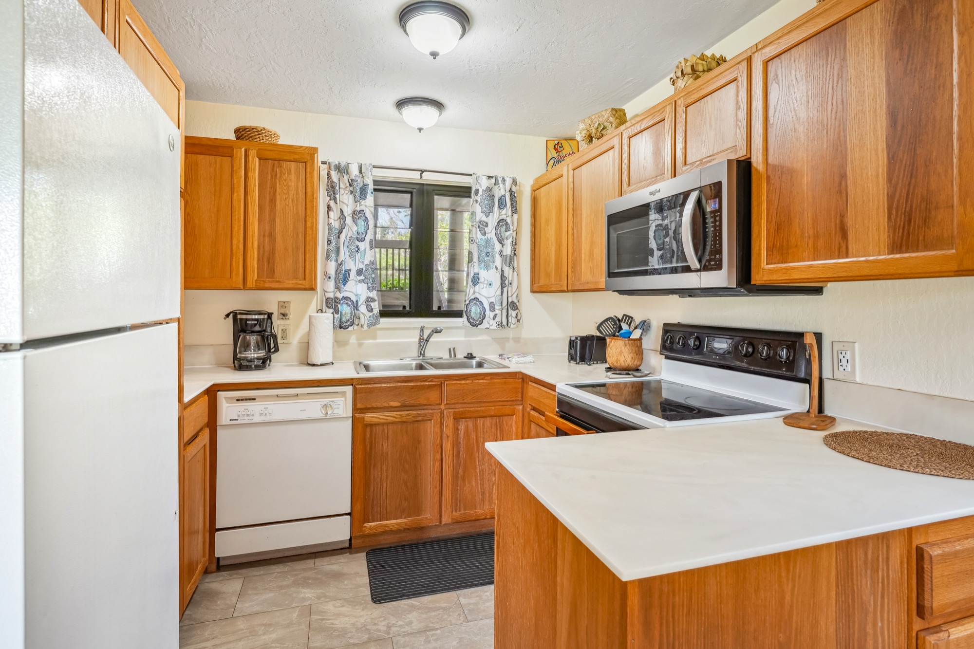 4460 Nehe Road, Unit 116 Lihue, HI 96766 - Photo 10 of 28 a kitchen that has a sink and a stove in it