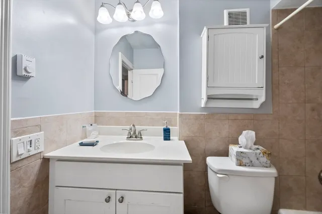 a bathroom with a toilet sink and mirror