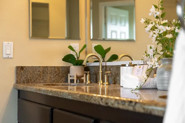 a spacious bathroom with a granite countertop tub sink and mirror
