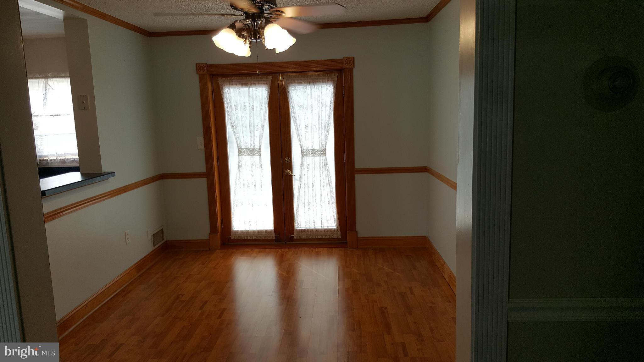 1943 Jasmine Road Baltimore, MD 21222 - Photo 6 of 29 a view of an empty room with wooden floor and a window