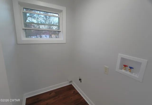a view of a small space with wooden floor and a window