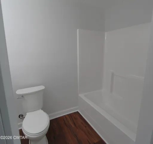 a white toilet sitting next to a bath tub