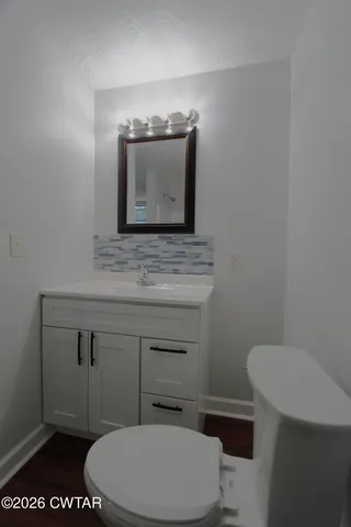 a bathroom with a toilet a sink and mirror